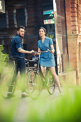 Image showing Young couple sitting on a bicycle opposite the city 