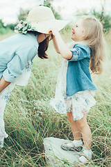 Image showing The young mother and daughter on green grass background 