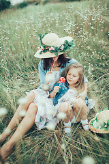 Image showing The young mother and daughter on green grass background 