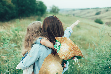 Image showing The young mother and daughter on green grass background 