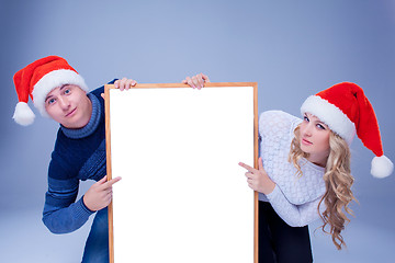 Image showing Christmas couple holding white board with empty copy space 