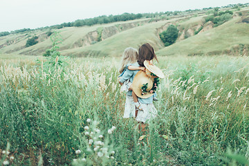 Image showing The young mother and daughter on green grass background 