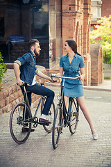 Image showing Young couple sitting on a bicycle opposite city 