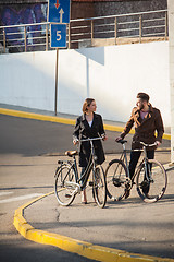 Image showing Young couple with on a bicycle opposite city 