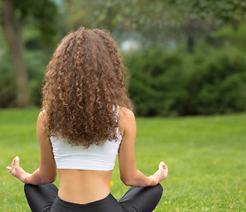 Image showing Pretty woman sitting back doing yoga meditation