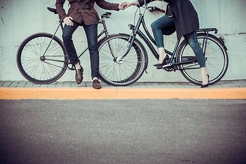 Image showing Young couple with a bicycle opposite city 