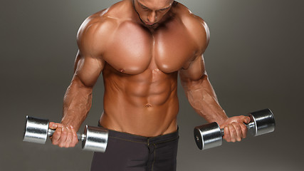 Image showing athletic man bodybuilder doing exercises with dumbbell 