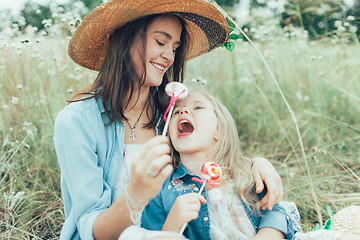 Image showing The young mother and daughter on green grass background 