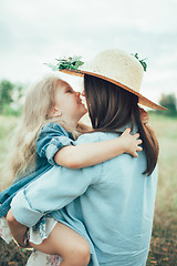 Image showing The young mother and daughter on green grass background 