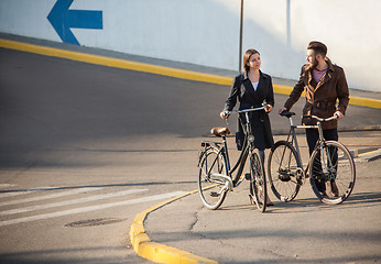 Image showing Young couple with on a bicycle opposite city 