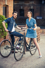 Image showing Young couple sitting on a bicycle opposite city 