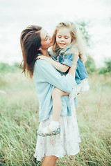 Image showing The young mother and daughter on green grass background 