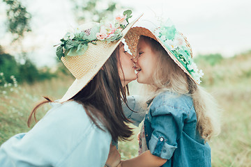 Image showing The young mother and daughter on green grass background 