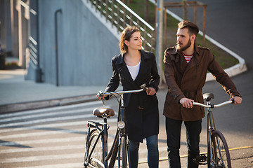 Image showing Young couple with on a bicycle opposite city 