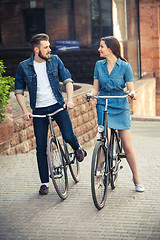 Image showing Young couple sitting on a bicycle opposite city 