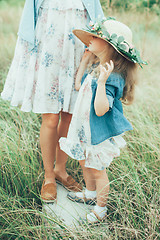 Image showing The young mother and daughter on green grass background 