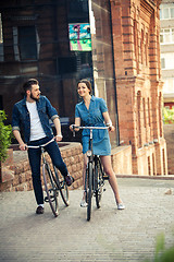 Image showing Young couple sitting on a bicycle opposite city 