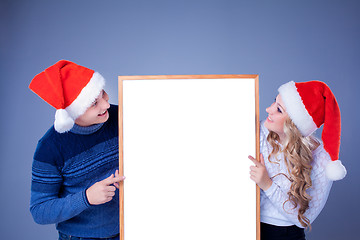 Image showing Christmas couple holding white board with empty copy space 