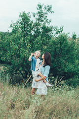 Image showing The young mother and daughter on green grass background 