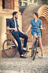 Image showing Young couple sitting on a bicycle opposite city 