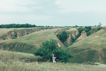 Image showing The young mother and daughter on green grass background 