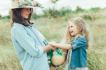 Image showing The young mother and daughter on green grass background 