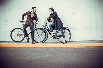 Image showing Young couple with a bicycle opposite city 