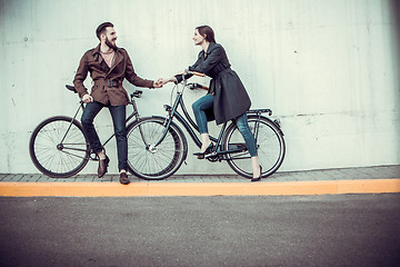 Image showing Young couple with a bicycle opposite city 