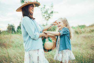 Image showing The young mother and daughter on green grass background 