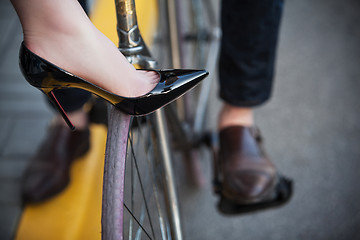 Image showing Young couple sitting on a bicycle opposite the city 