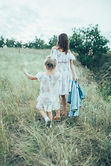 Image showing The young mother and daughter on green grass background 