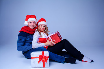 Image showing Lovely christmas couple sitting with presents