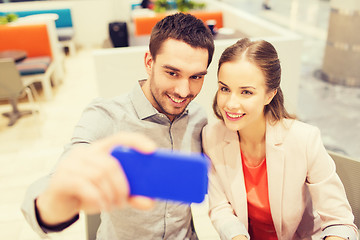 Image showing happy couple taking selfie with smartphone in cafe