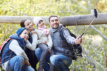 Image showing happy family with smartphone selfie stick in woods