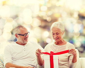 Image showing happy senior couple with gift box at home