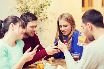 Image showing group of friends with smartphones meeting at cafe
