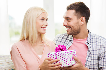 Image showing happy man giving woman gift box at home