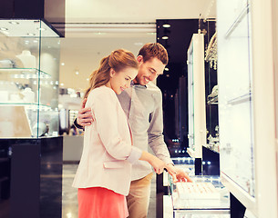 Image showing happy couple choosing engagement ring in mall