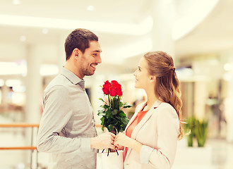 Image showing happy young couple with flowers in mall