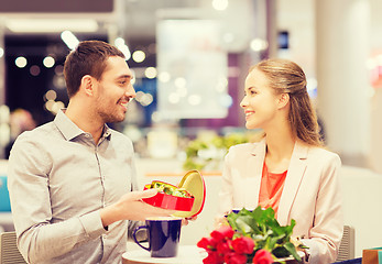 Image showing happy couple with present and flowers in mall