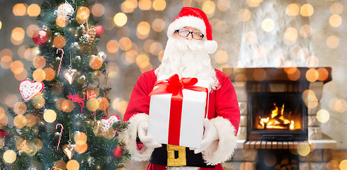 Image showing santa claus with gift and christmas tree at home