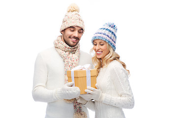 Image showing smiling couple in winter clothes with gift box