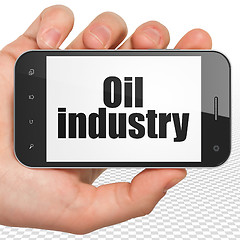 Image showing Industry concept: Hand Holding Smartphone with Oil Industry on display