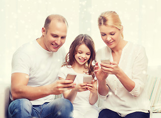 Image showing happy family with smartphones at home