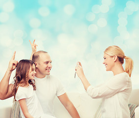 Image showing happy family with camera at home