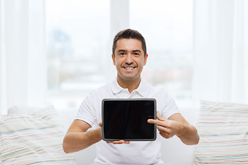 Image showing smiling man showing tablet pc blank screen at home