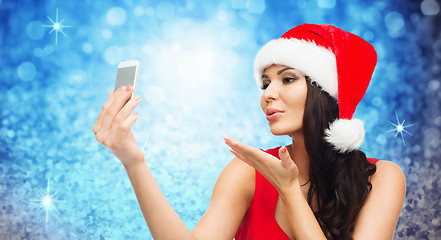 Image showing woman in santa hat taking selfie by smartphone