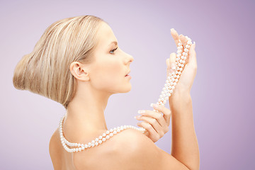 Image showing beautiful woman with pearl necklace over violet