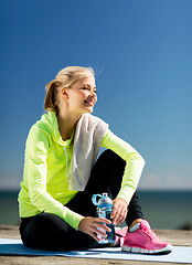 Image showing woman resting after doing sports outdoors