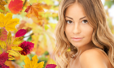 Image showing beautiful young woman face over autumn leaves